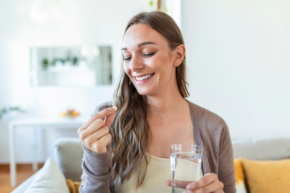 A woman happily takes probiotics