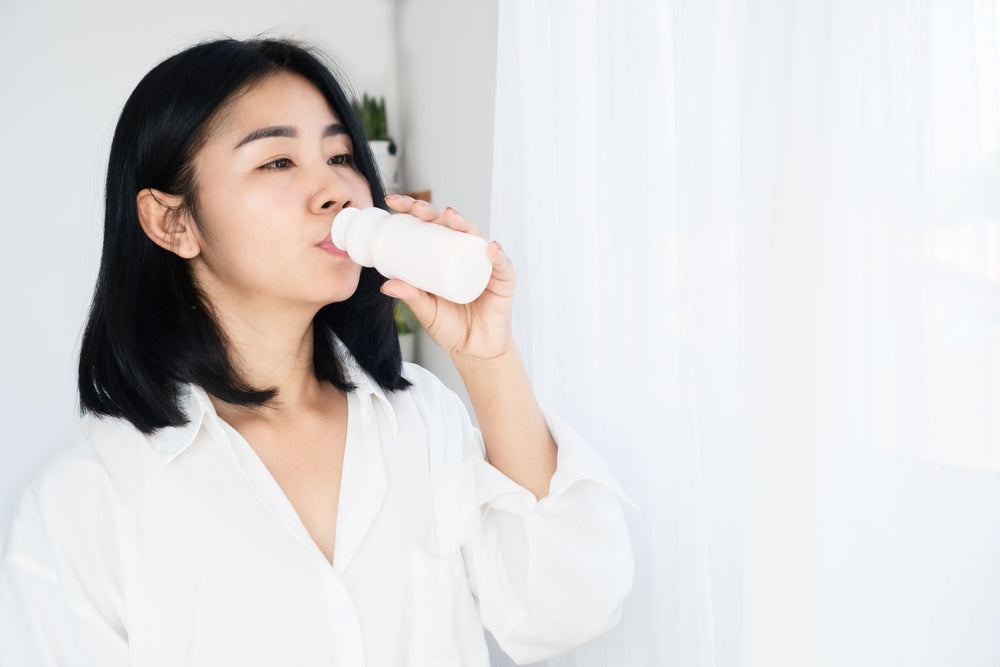 An image of a woman drinking probiotic drinks