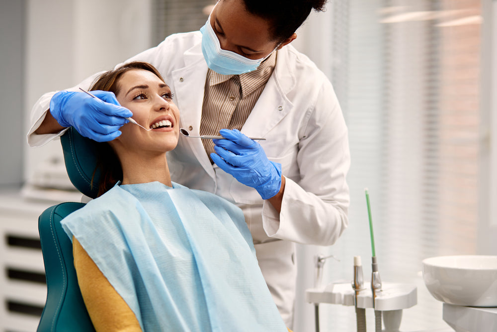 A woman removing dental plaque at a dentist's