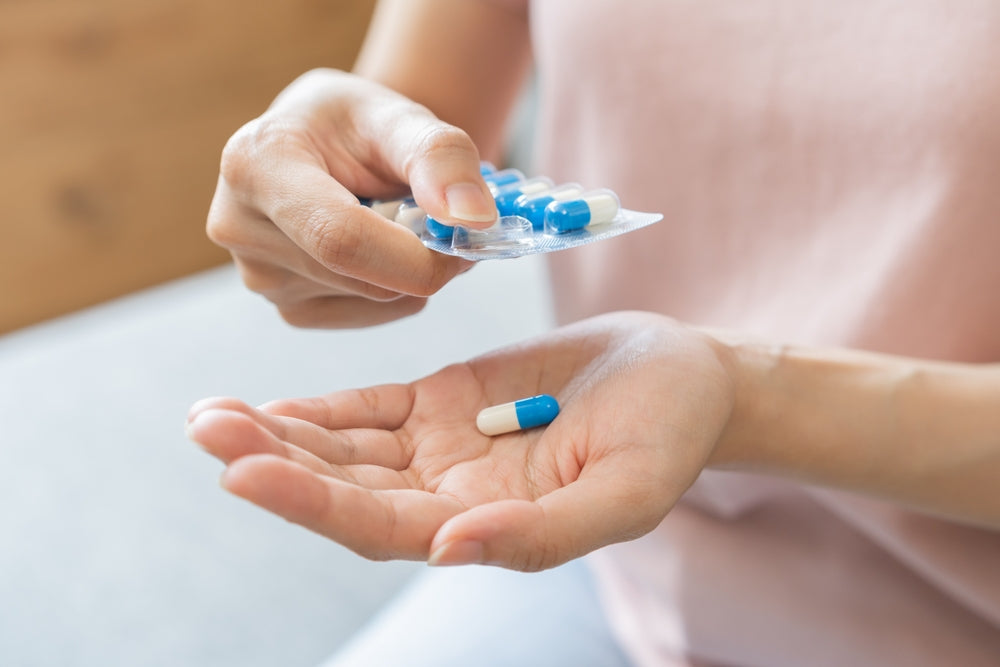 An image of a woman taking antibiotics